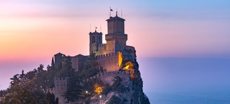 sunset on a solid looking castle in the distance