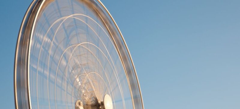 ferris wheel spinning with blue sky behind it