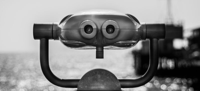 vintage black and white picture of an old metal viewing machine and water in the distance