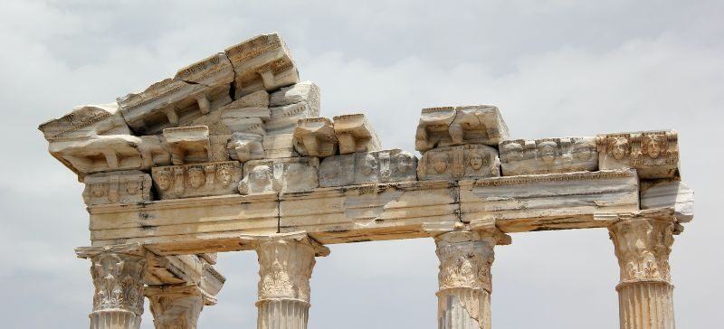 crumbling stone archway with grey sky in the background