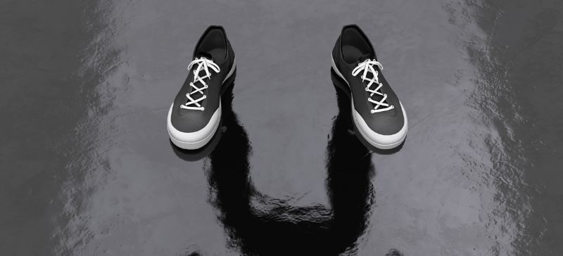 a pair of empty shoes cast a full persons shadow in optical illusion