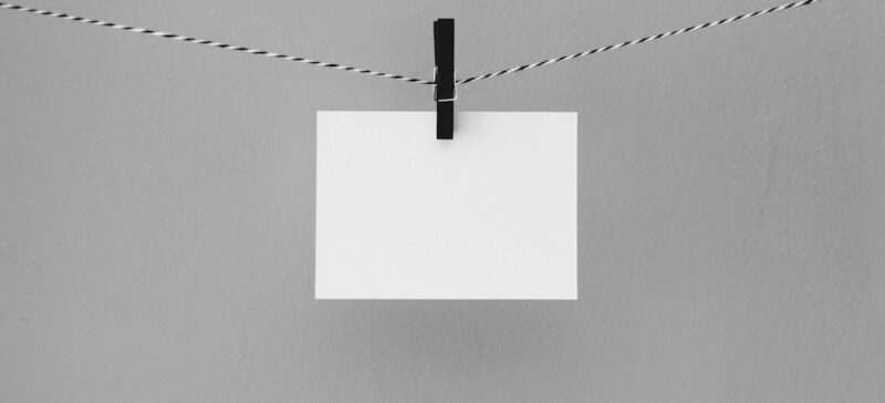 A simple white notecard being held by a clothespin