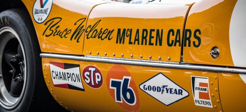 A McLaren racecar with the following logos: Valvoline, Champion, STP, 76, GoodYear, Fram Filters