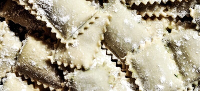 A pile of raw ravioli dusted with flour