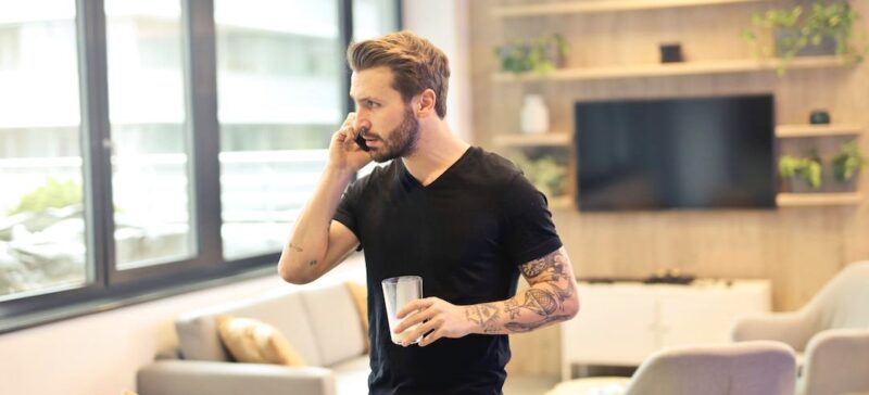 Man talking on the phone holding a glass of milk