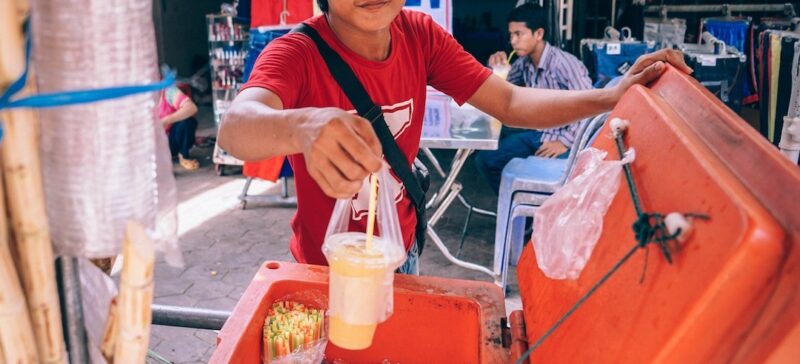 Kid holding out a drink in a plastic cup