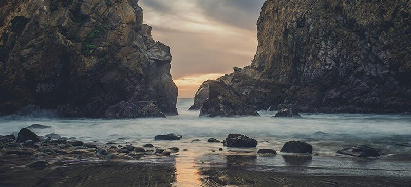 A river flows in the gap between two steep rocks cliff faces. Challenging to navigate, but beautiful and rewarding to overcome.